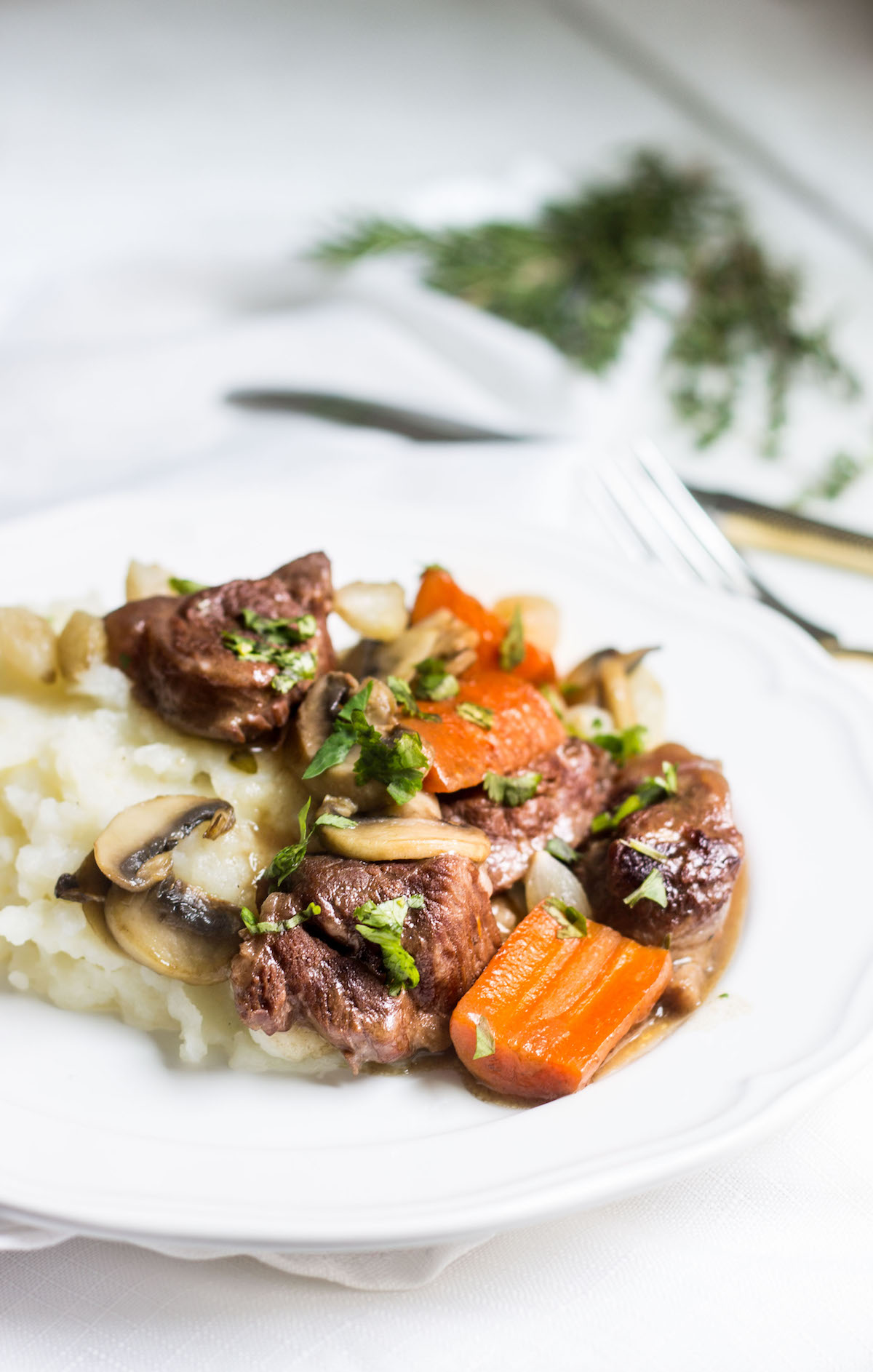 Beef Bourguignon: slow-cooked beef stew served with carrots, mushrooms, and mashed potatoes. Recipe via MonPetitFour.com