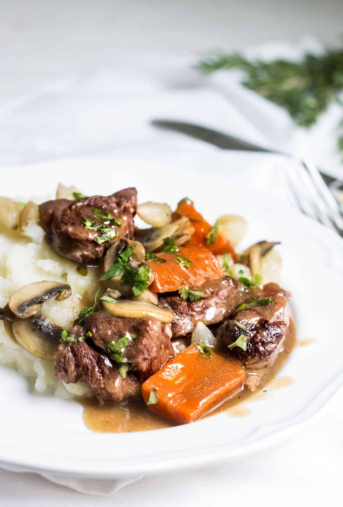 Beef Bourguignon: slow-cooked beef stew served with carrots, mushrooms, and mashed potatoes. Recipe via MonPetitFour.com