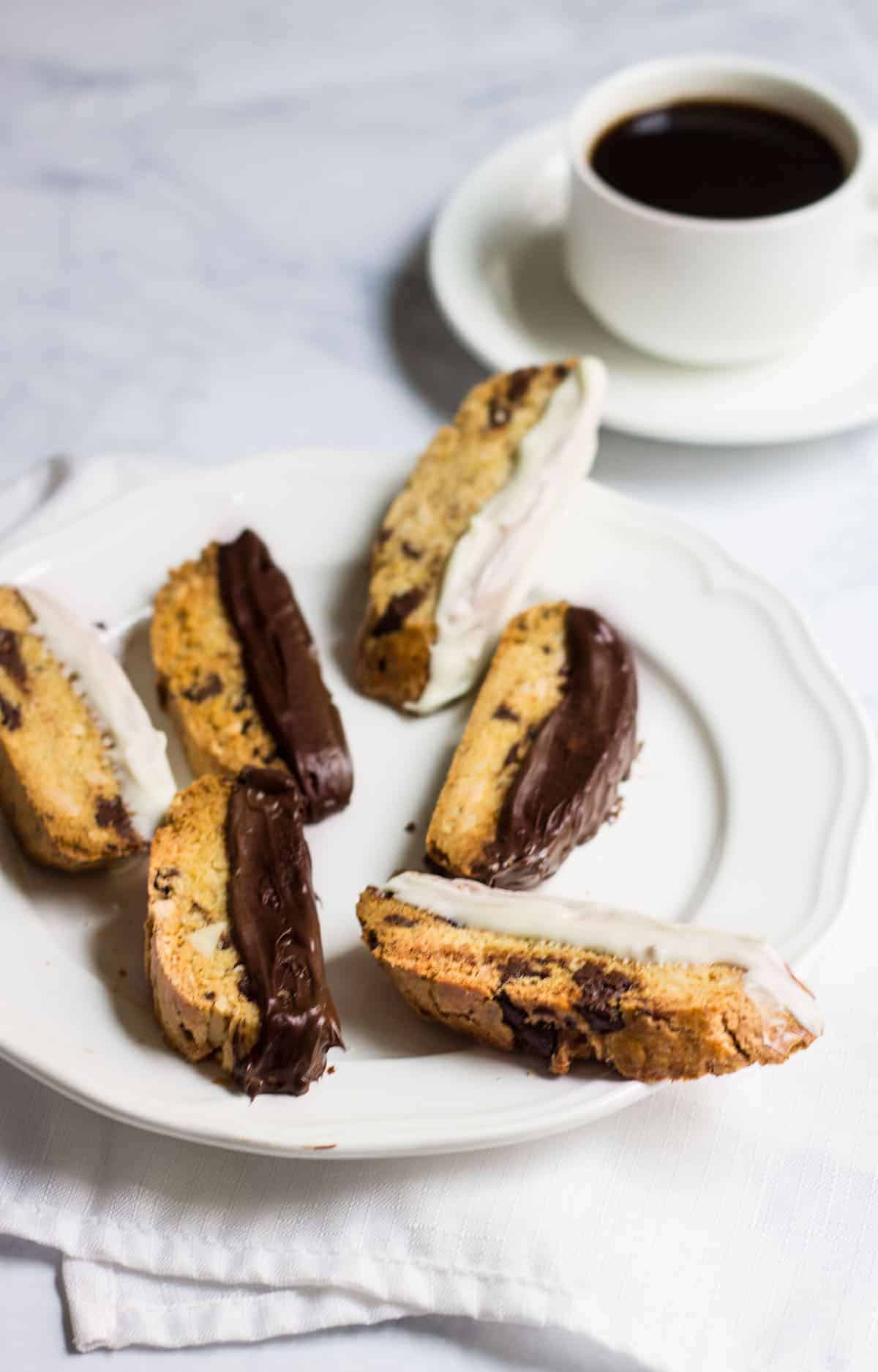 Chocolate-Dipped Almond Biscotti: a crisp almond cookie filled with dark chocolate, orange zest, and almonds. Perfect as a winter dessert, served with a cup of hot coffee. Recipe via MonPetitFour.com