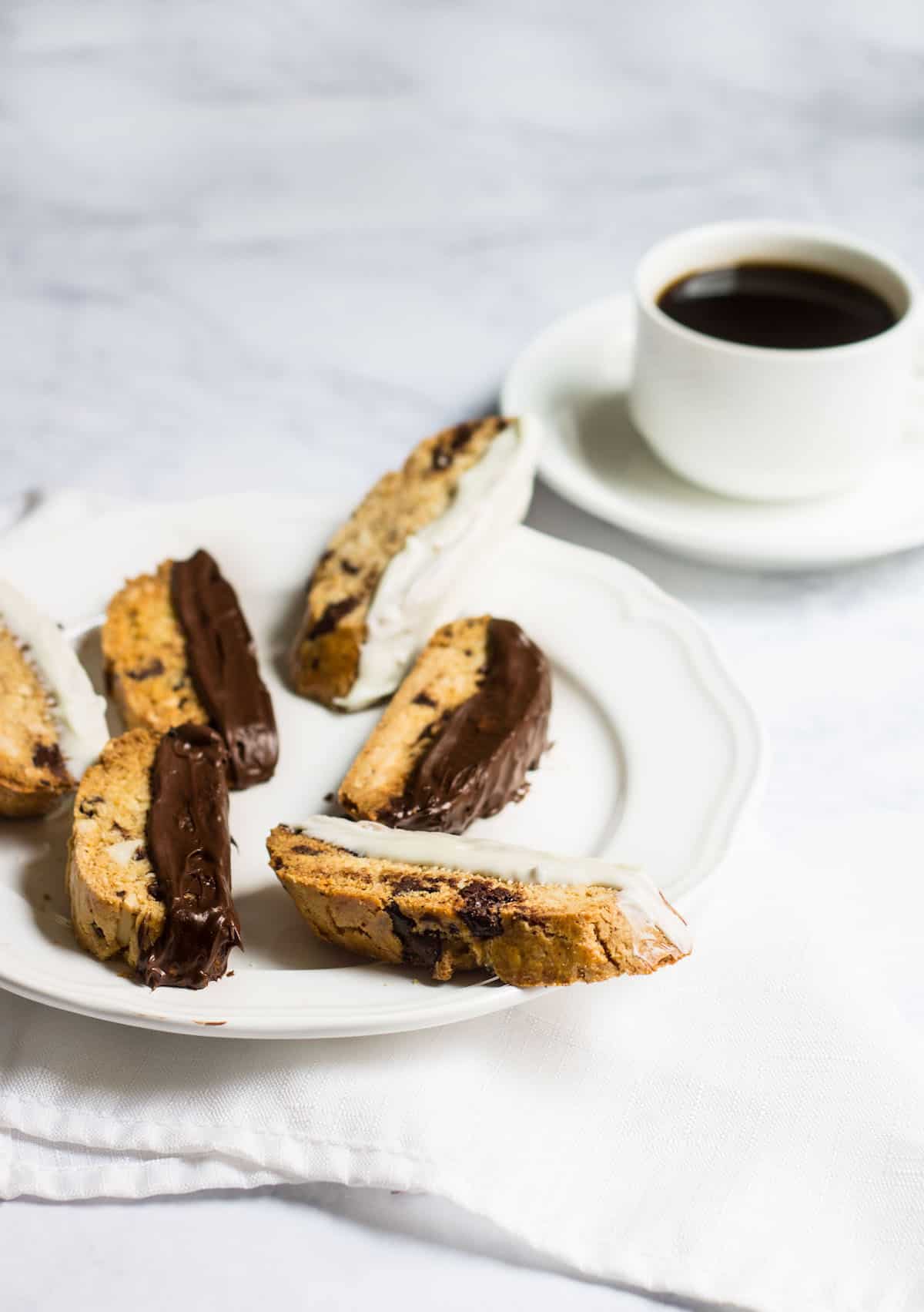 Chocolate-Dipped Almond Biscotti: a crisp almond cookie filled with dark chocolate, orange zest, and almonds. Perfect as a winter dessert, served with a cup of hot coffee. Recipe via MonPetitFour.com