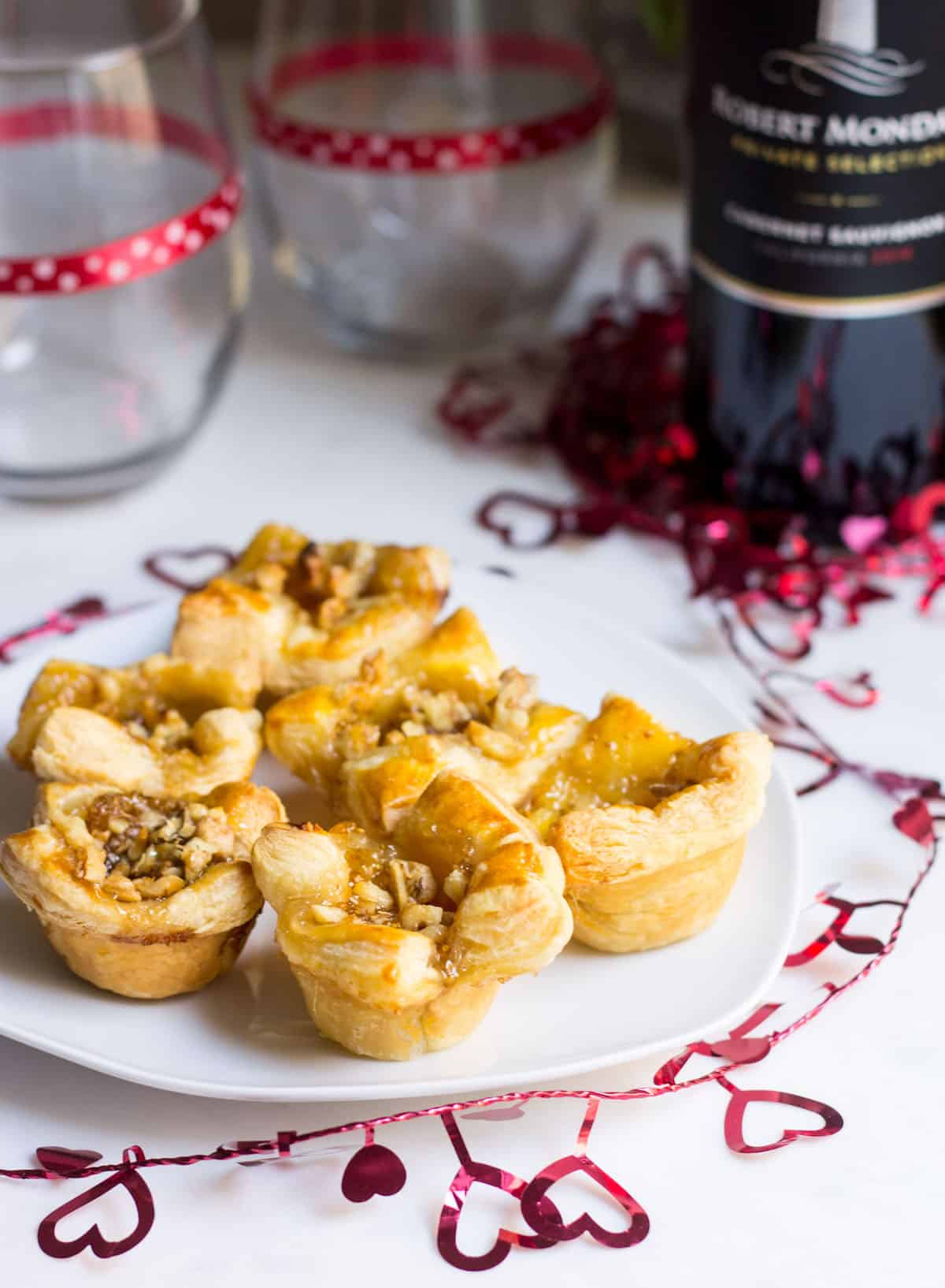 Fig Brie Bites perfect for entertaining! Creamy brie inside golden puff pastry, topped with sweet fig preserves and crunchy walnut pieces. Recipe via MonPetitFour.com