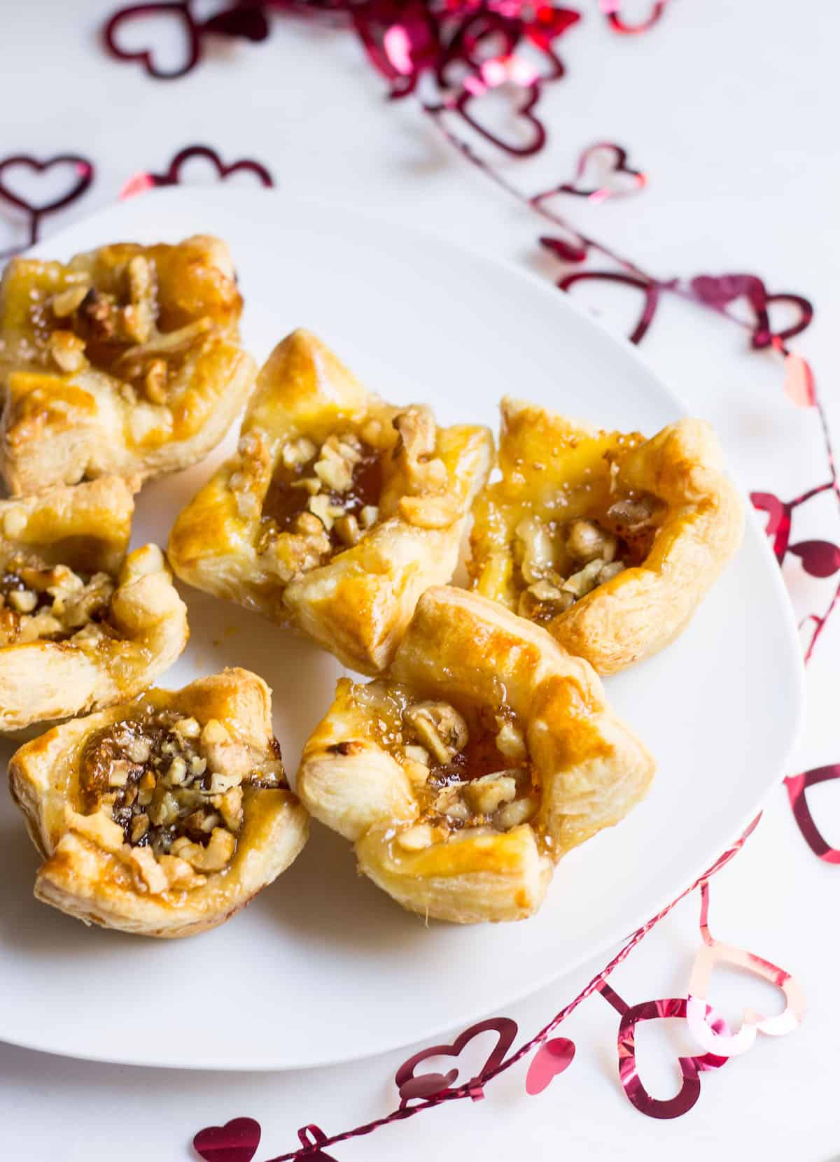 Fig Brie Bites perfect for entertaining! Creamy brie inside golden puff pastry, topped with sweet fig preserves and crunchy walnut pieces. Recipe via MonPetitFour.com
