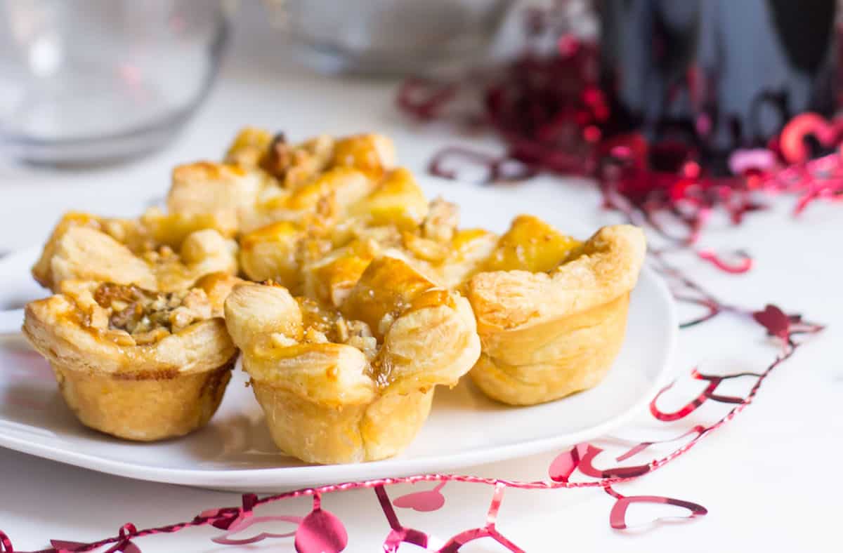 Fig Brie Bites perfect for entertaining! Creamy brie inside golden puff pastry, topped with sweet fig preserves and crunchy walnut pieces. Recipe via MonPetitFour.com