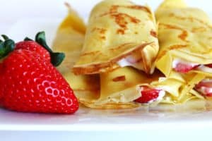 french crepes with whipped cream and strawberries