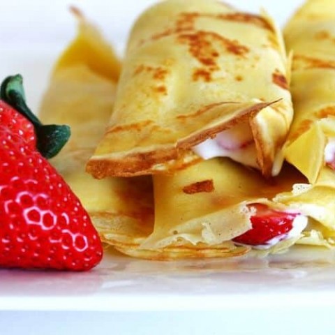french crepes with whipped cream and strawberries