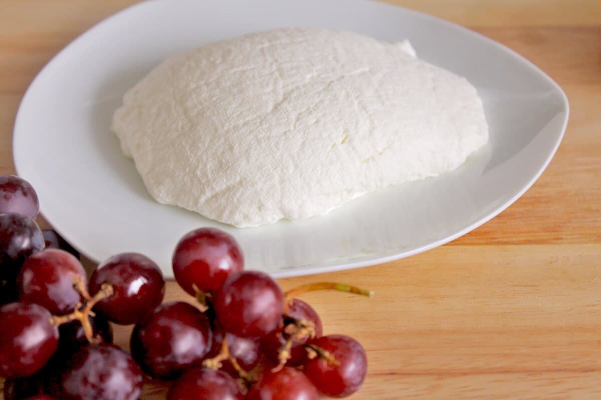 homemade ricotta cheese next to grapes