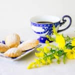 Madeleines recipe on a plate next to a cup of coffee