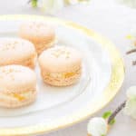 French macarons on a gold rim plate with flowers