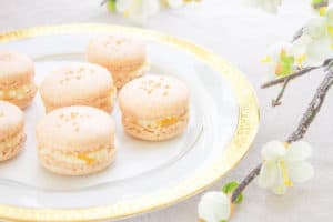 French macarons on a gold rim plate with flowers
