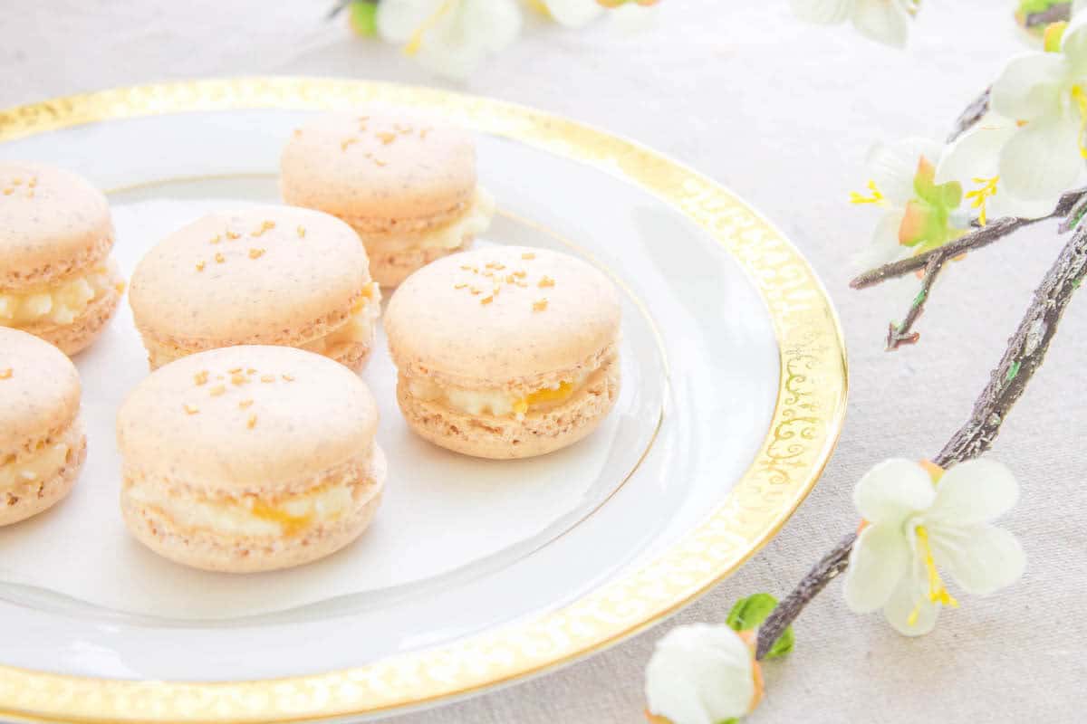 French macarons on a gold rim plate with flowers