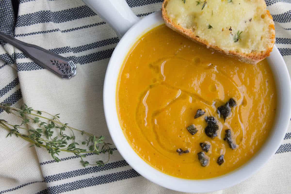 instant pot butternut squash soup recipe in a bowl with crispy sage leaves for a garnish