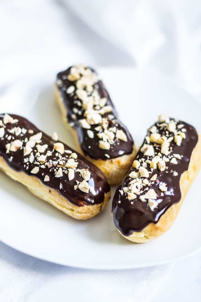 chocolate eclairs with ganache and hazelnuts on top