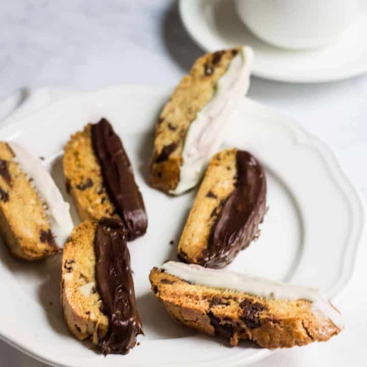 Chocolate-Dipped Almond Biscotti: a crisp almond cookie filled with dark chocolate, orange zest, and almonds. Perfect as a winter dessert, served with a cup of hot coffee. Recipe via MonPetitFour.com