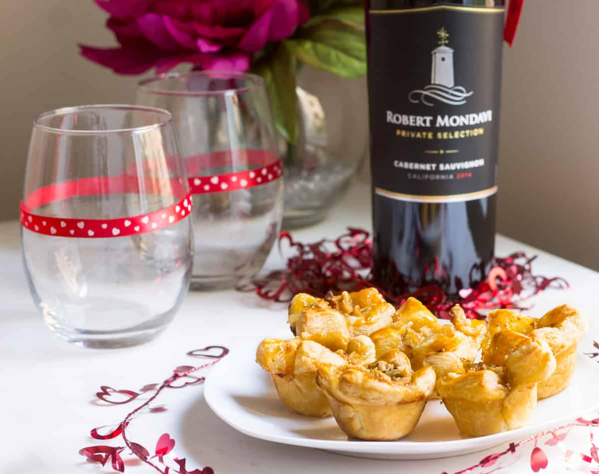 Fig Brie Bites perfect for entertaining! Creamy brie inside golden puff pastry, topped with sweet fig preserves and crunchy walnut pieces. Recipe via MonPetitFour.com
