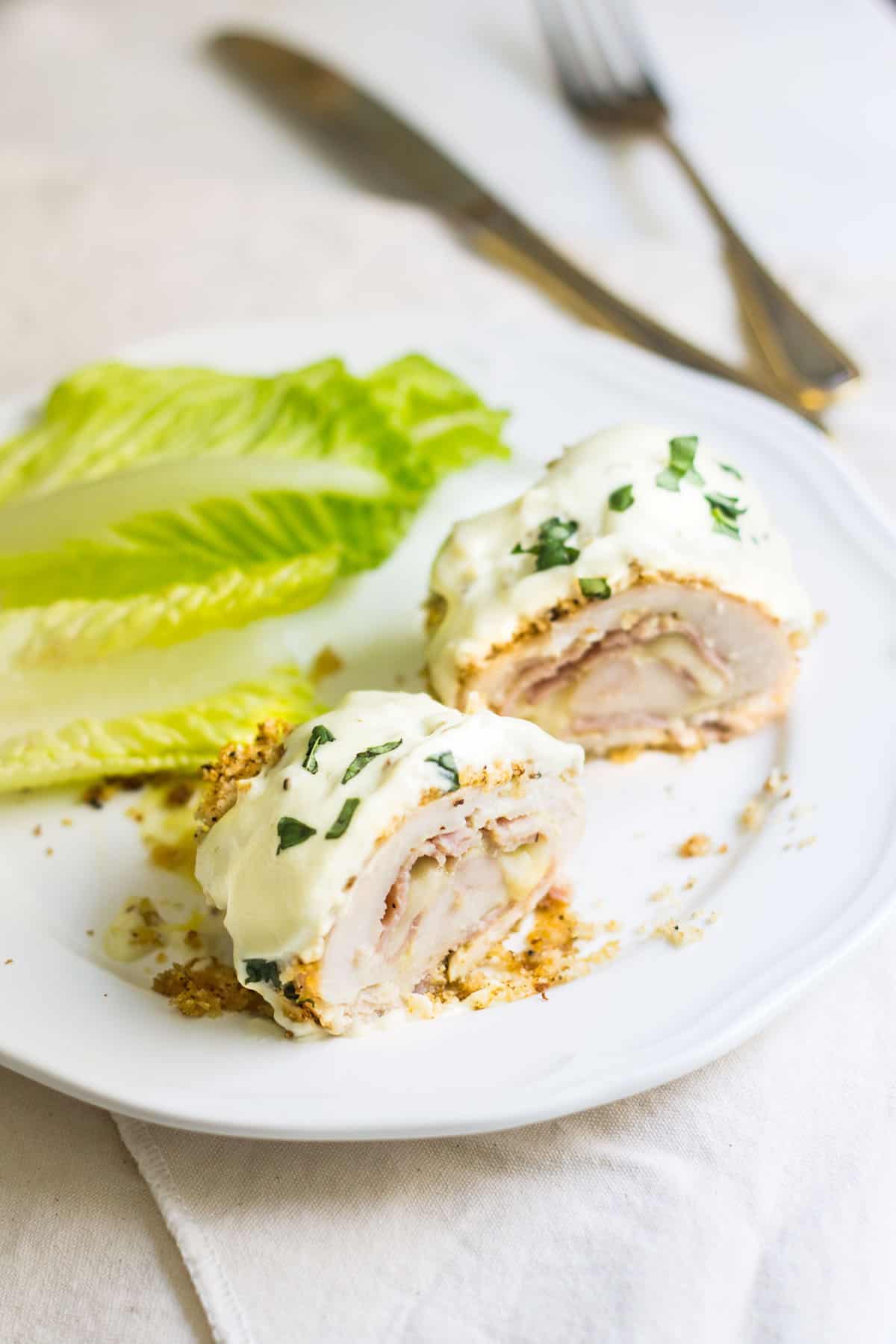 Chicken Cordon Bleu: an easy and quick French dinner! This classic is made with breaded chicken stuffed with ham and cheese. Topped with a dijon cream sauce. Recipe via MonPetitFour.com