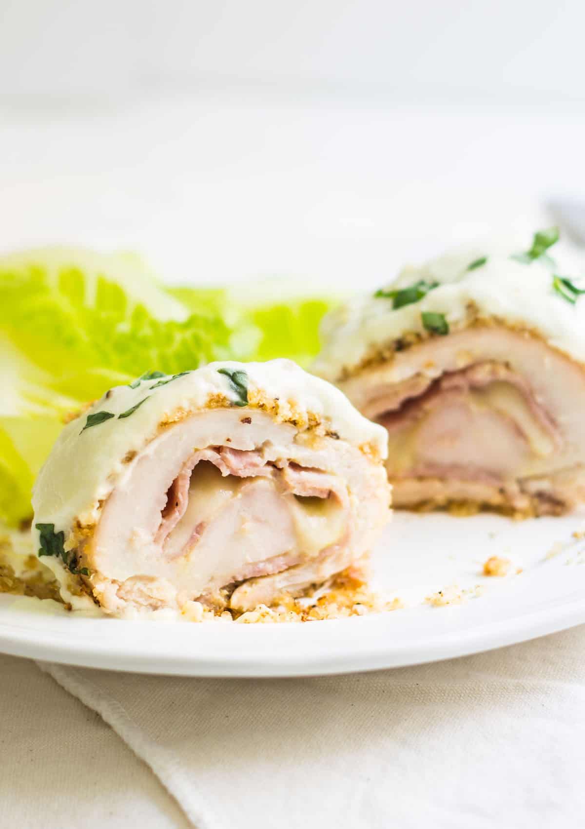 Chicken Cordon Bleu: an easy and quick French dinner! This classic is made with breaded chicken stuffed with ham and cheese. Topped with a dijon cream sauce. Recipe via MonPetitFour.com