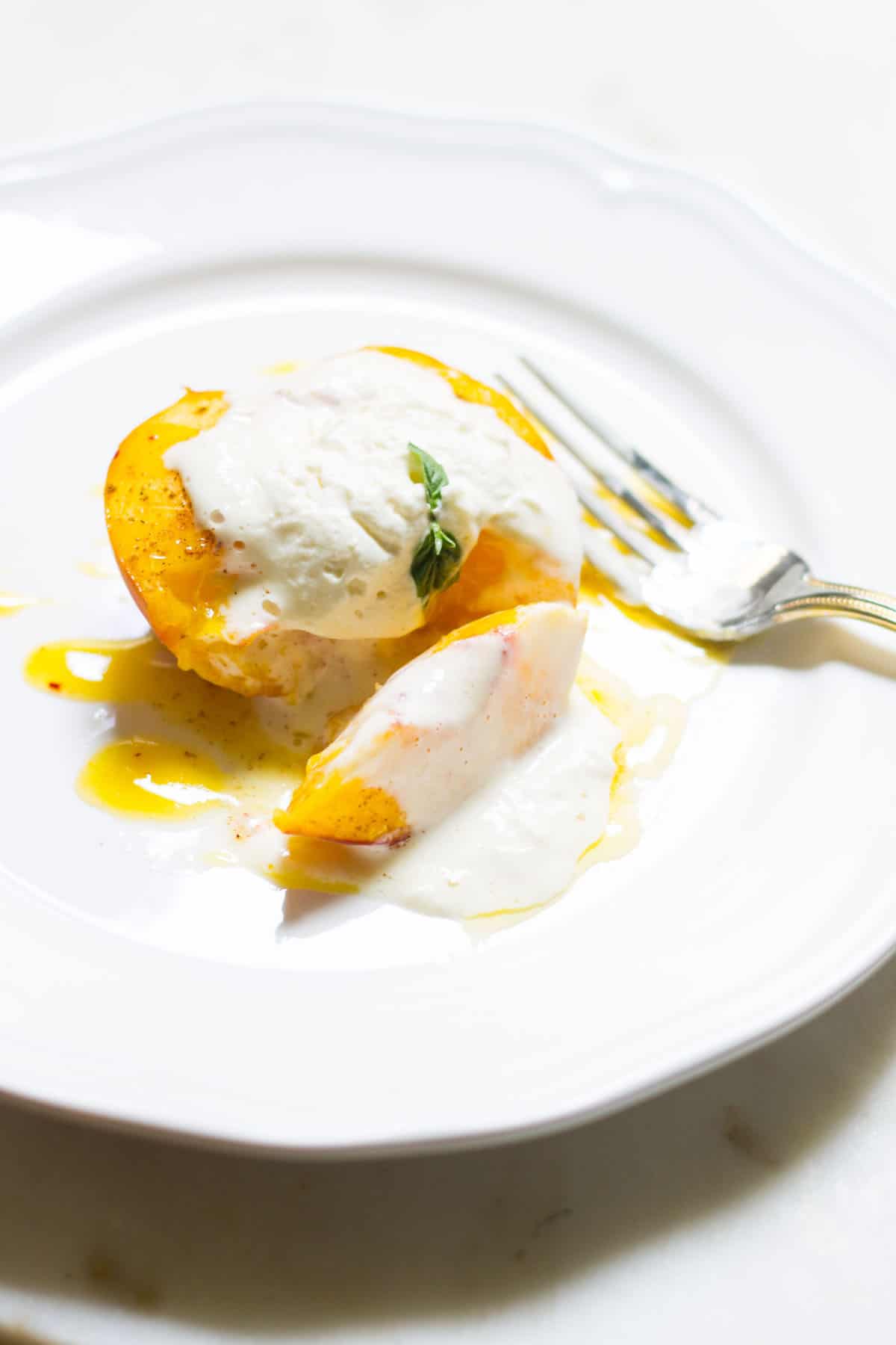 Baked Peaches with Cream: a quick and easy summer dessert made with ripe peaches and freshly whipped cream. A French recipe known as pêches rôties. Recipe via MonPetitFour.com