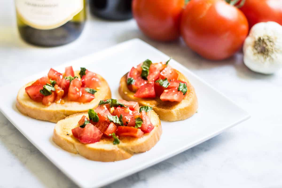 Tomato Crostini: easy appetizer idea using fresh tomatoes, basil, and garlic-flavored baguette slices. French recipe via MonPetitFour.com