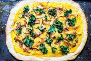 Butternut Squash Pizza: a fall pizza made with butternut squash sauce, gruyere cheese, crispy kale, and crispy shallots all on a homemade pizza crust. Recipe via MonPetitFour.com