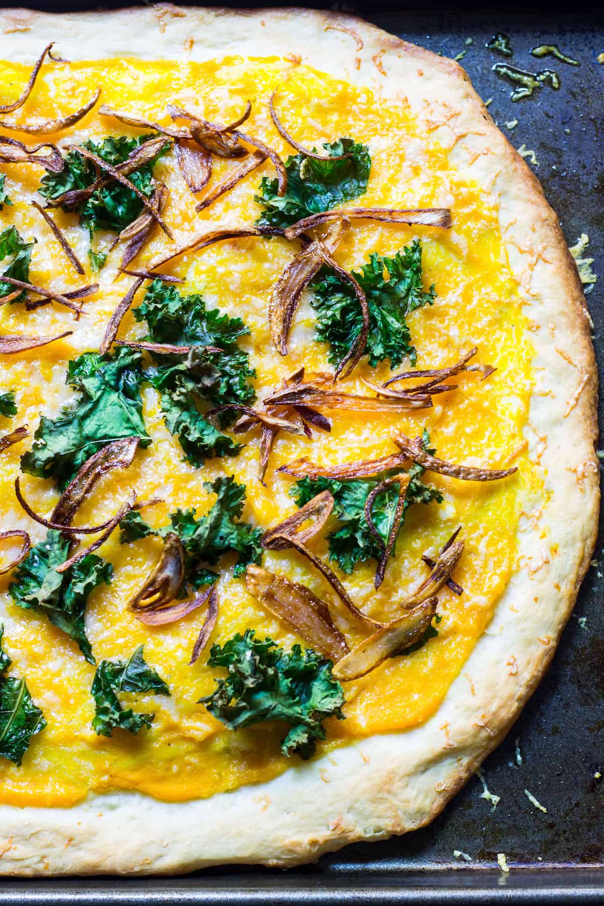 Butternut Squash Pizza: a fall pizza made with butternut squash sauce, gruyere cheese, crispy kale, and crispy shallots all on a homemade pizza crust. Recipe via MonPetitFour.com