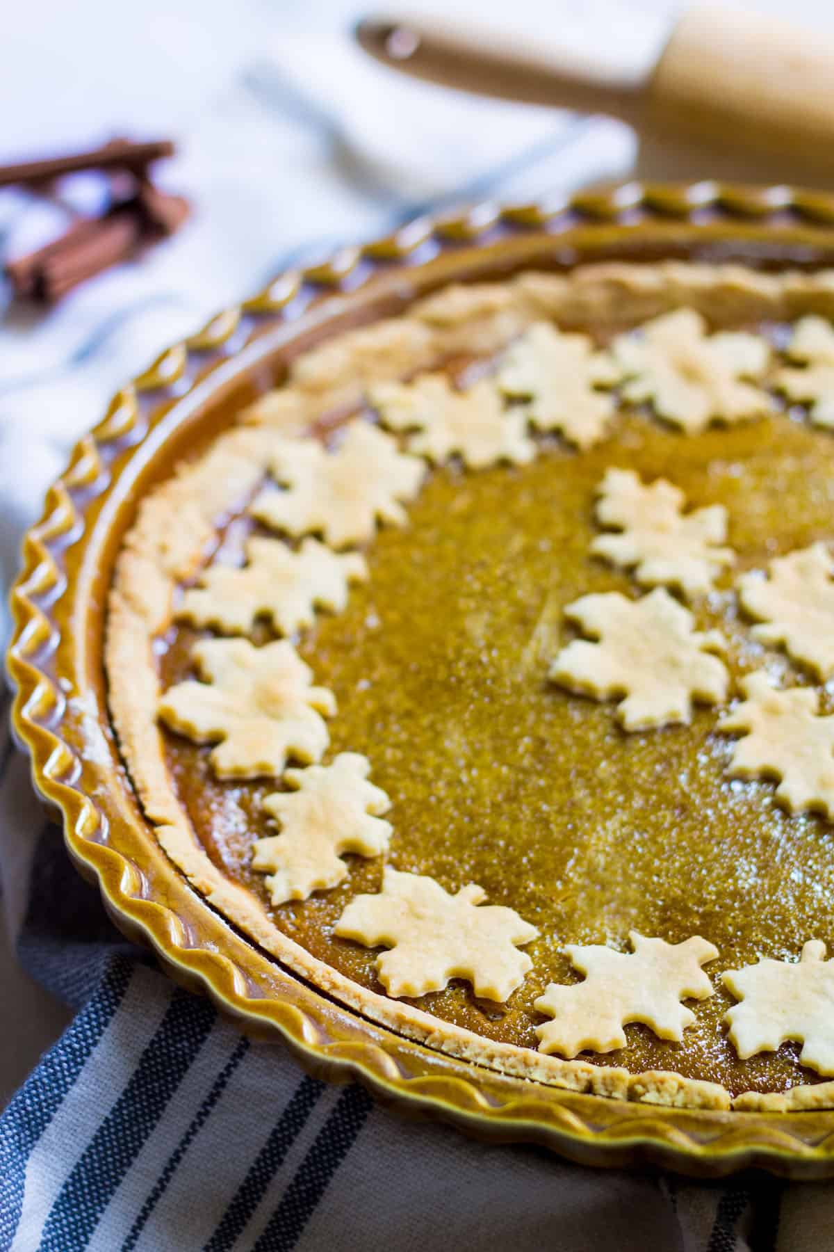 Homemade Pumpkin Pie in a pie dish with cut out leaves on top