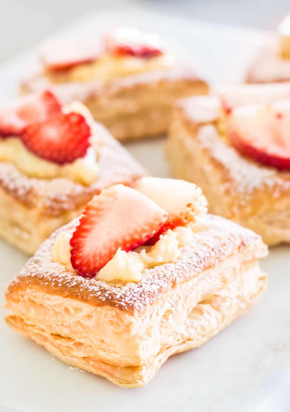 Strawberry croissants close-up shot of puff pastry layers and custard