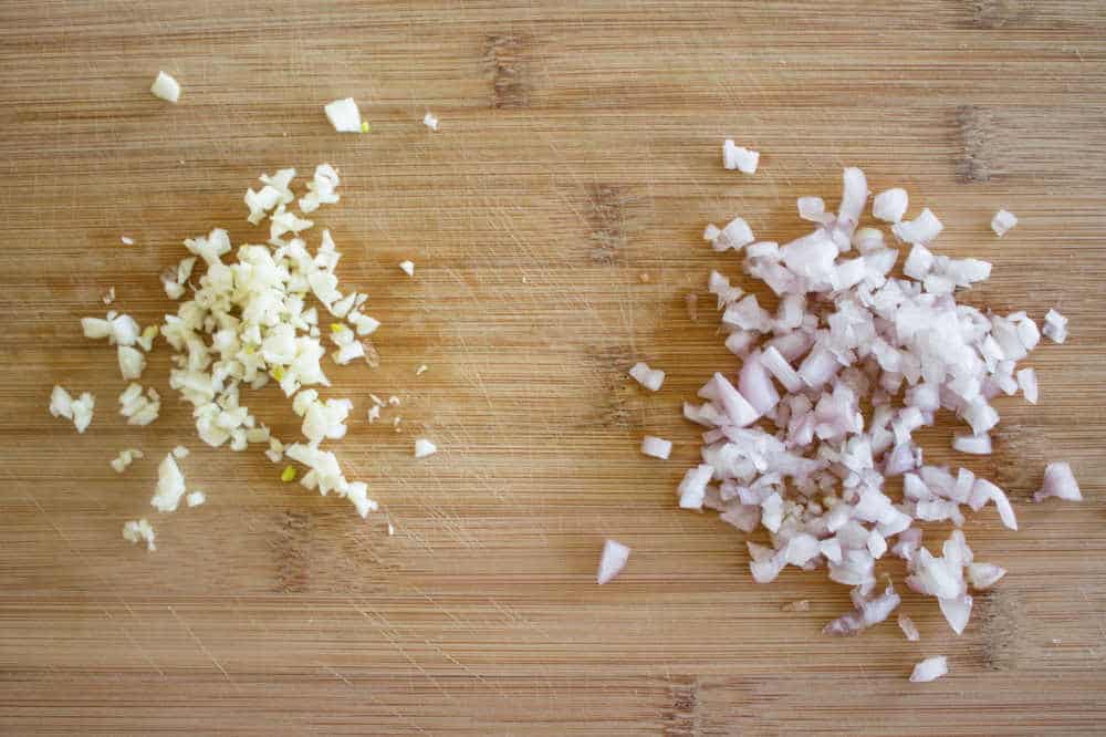 Simple Bolognese Recipe minced garlic and shallot on cutting board