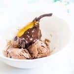 poached pear covered in chocolate sauce served with chocolate ice cream