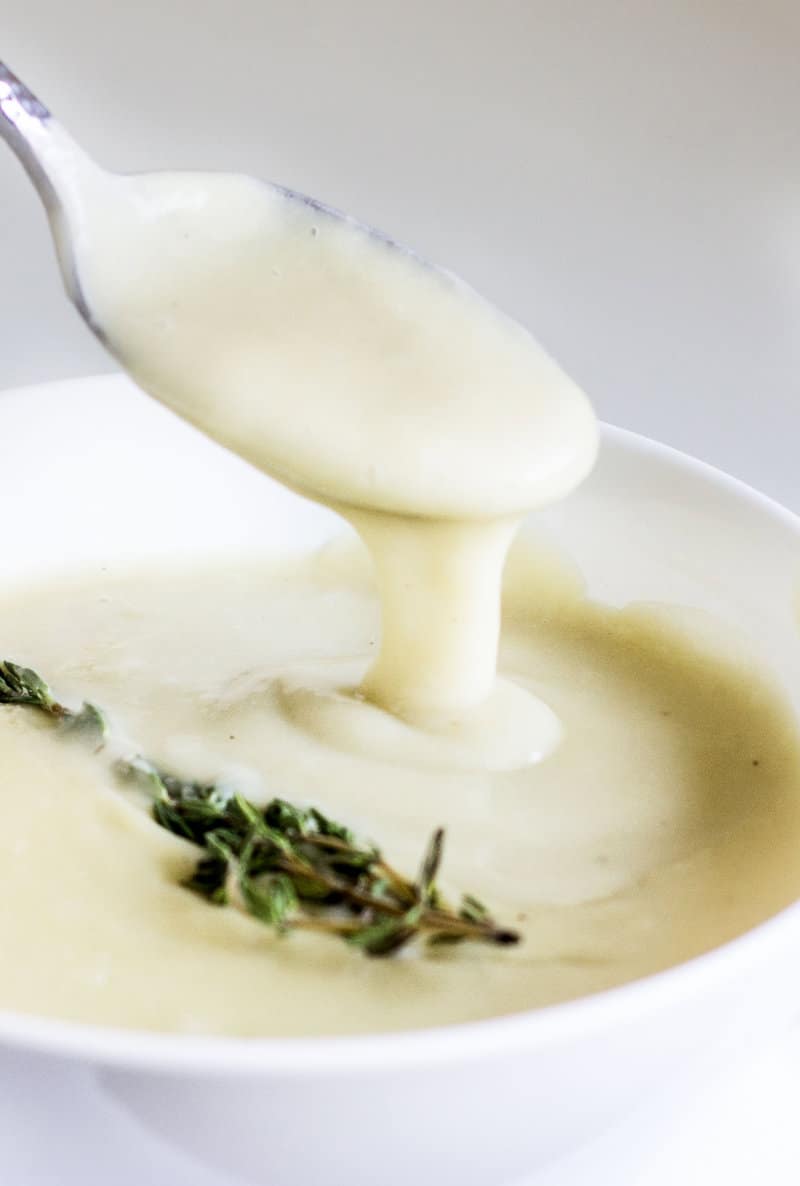 close up of leek soup falling off spoon