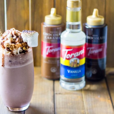 s'mores milkshake in a cup next to Torani syrups and sauces
