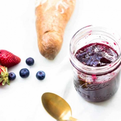 Mixed Berry Jam in a jar next to baguette