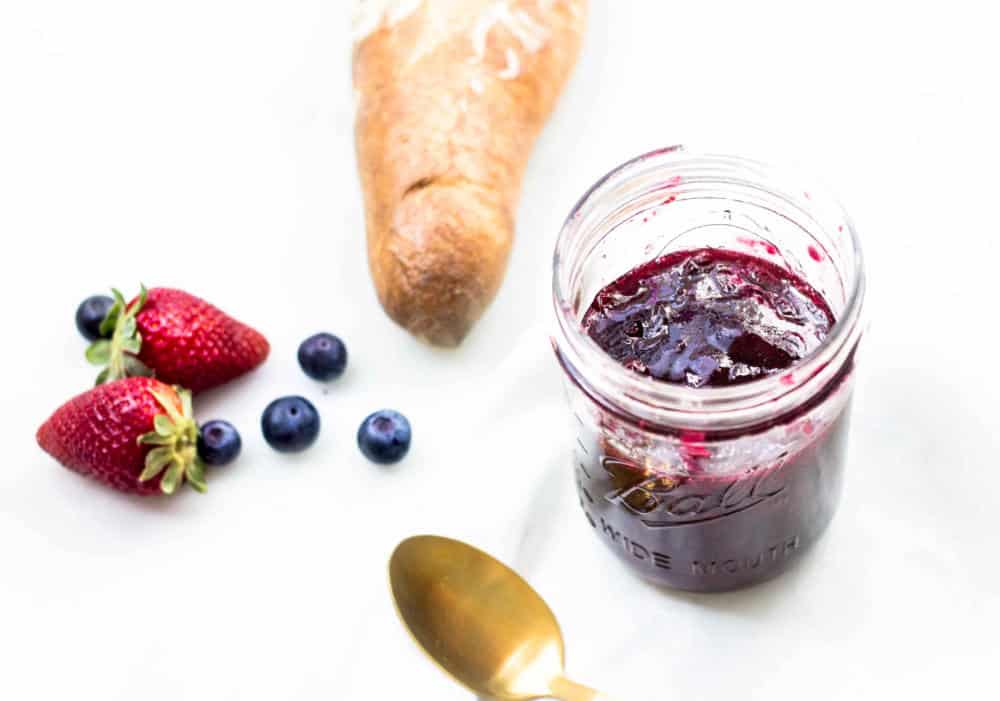 Mixed Berry Jam in a jar next to baguette