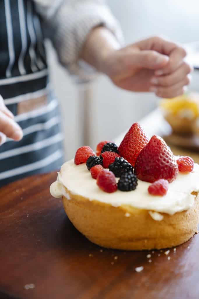 Person Holding a Bread With Strawberry and Cream
