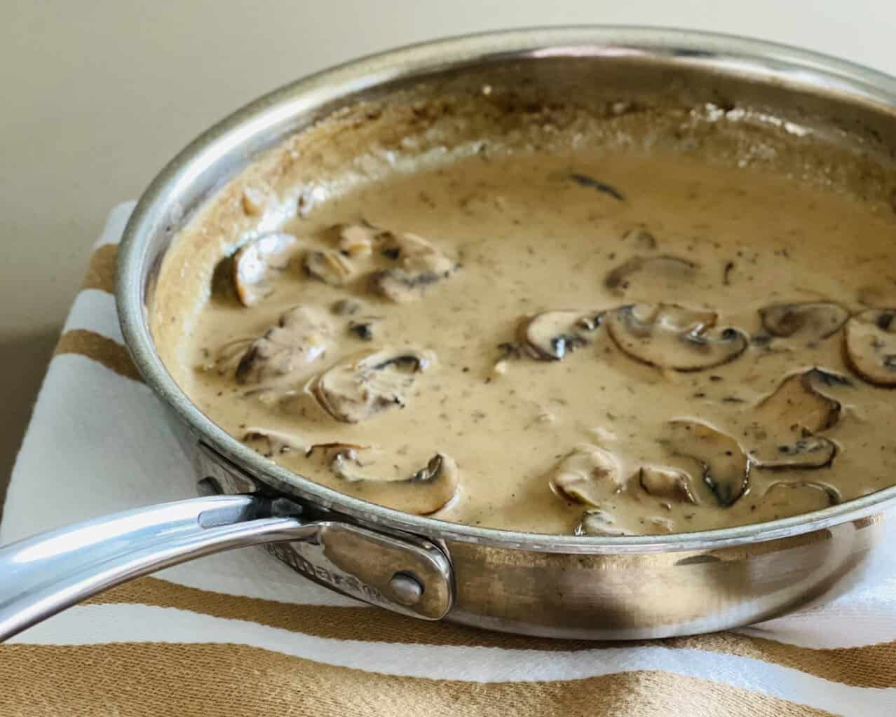 sauce forestiere recipe in a pan sitting on a kitchen towel