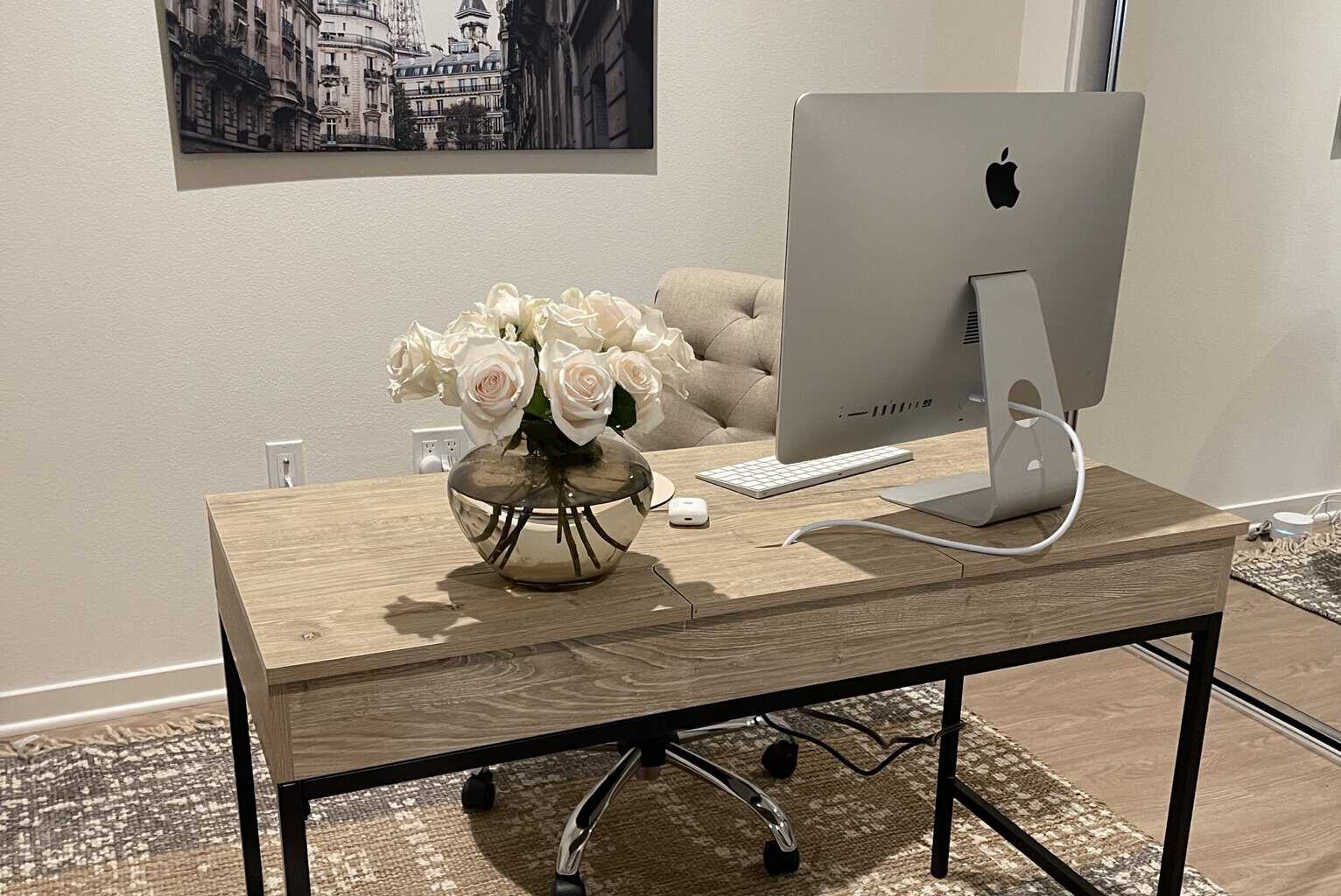 photo of office desk with computer and flowers