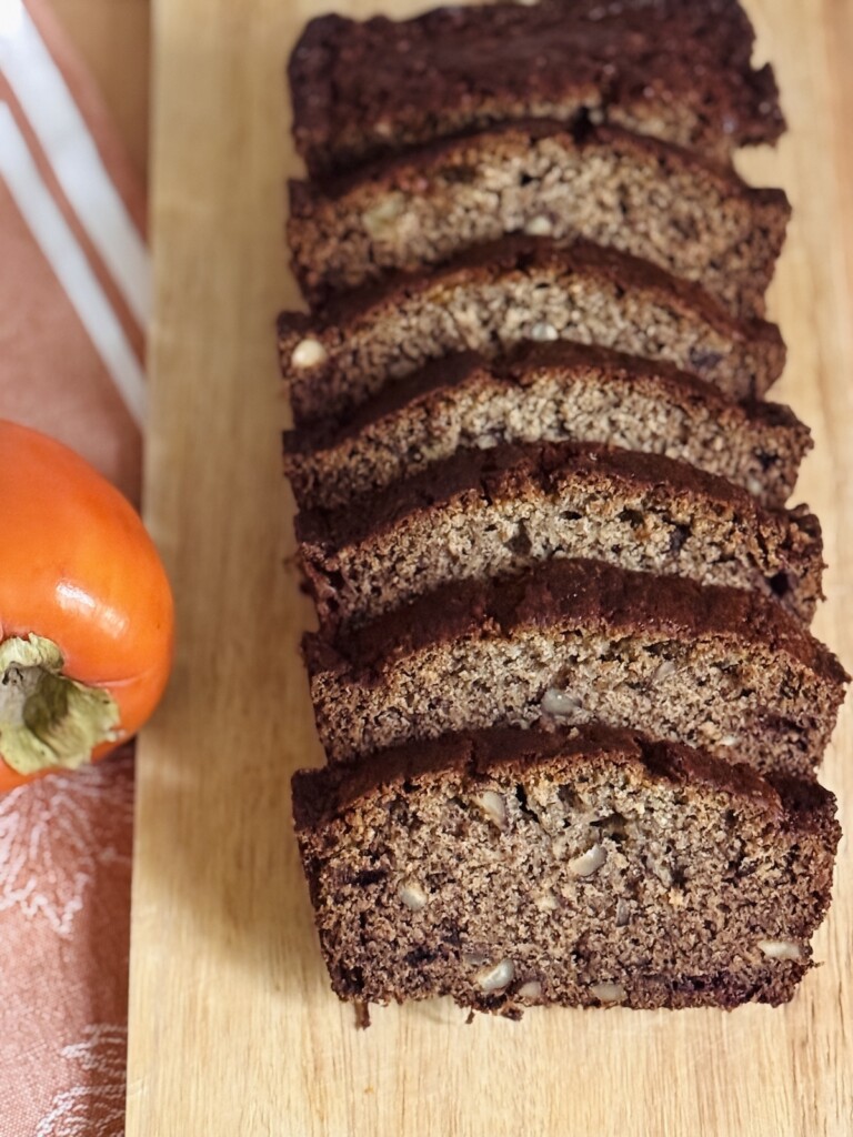 persimmon bread sliced on a wooden board