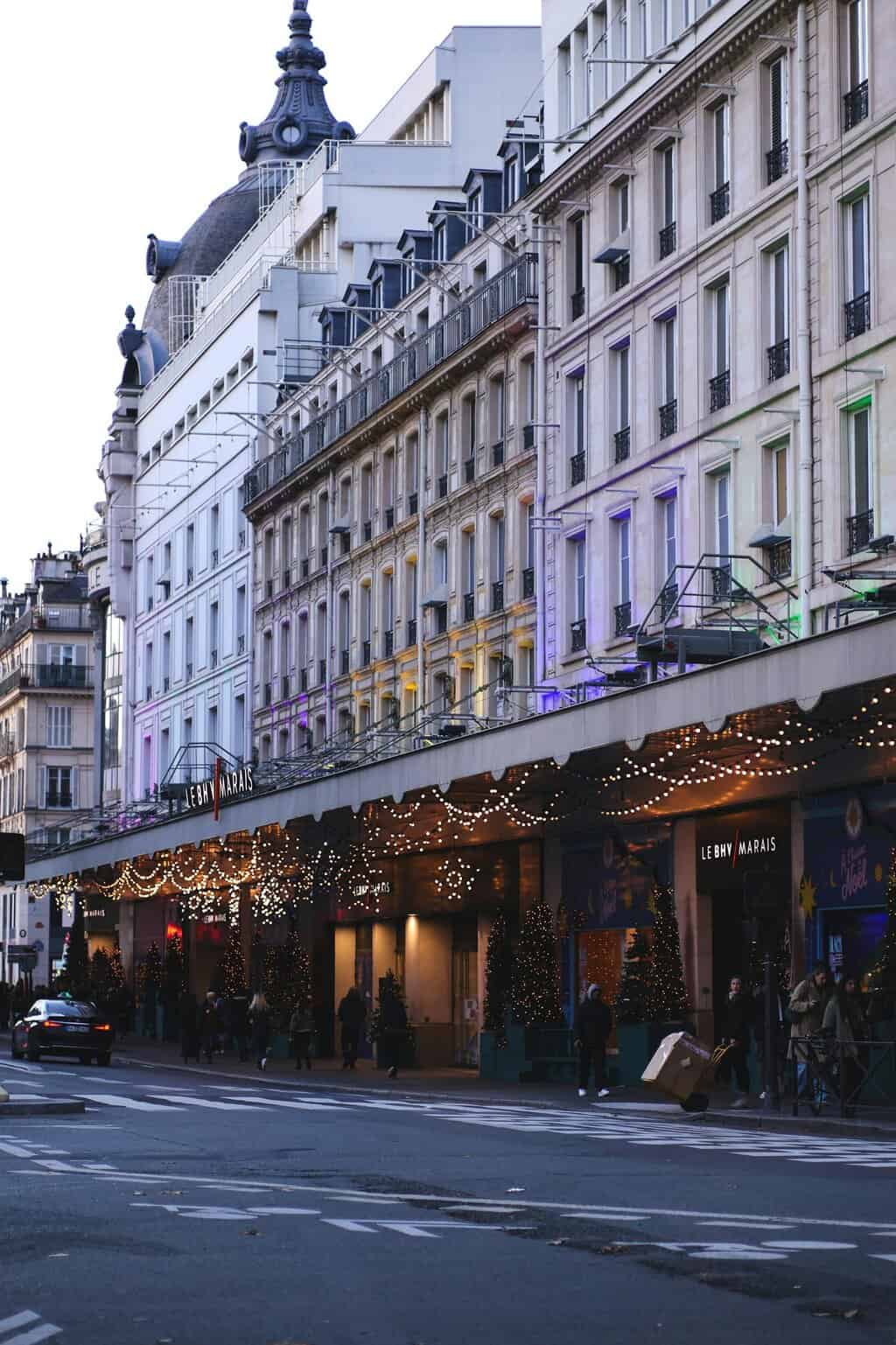 Parisian street adorned with festive lights and holiday decorations, capturing the spirit of winter season.