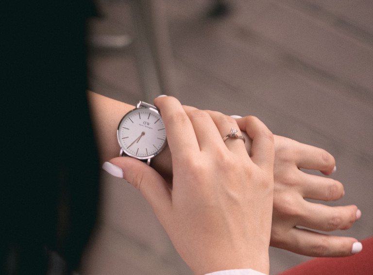 Adult woman with casual clothing checking time on wristwatch.